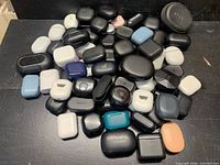 Group shot of entire assortment of charging cases piled on surface