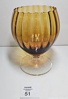 Front view of amber ribbed glass snifter on clear stem