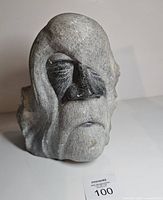 Front view showing carved facial features and signature label