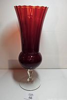 Front view of tall deep red vase on clear foot