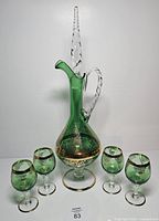 front view of decanter with stopper and four goblets