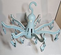 front view of light blue Ikea Pressa octopus hanger showing arms and clips