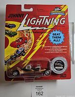 Front of sealed Johnny Lightning Commemorative Limited Edition blister pack showing gold roadster and collector coin