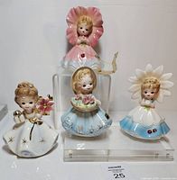 Group shot of all four Josef Originals Flower Girl figurines on acrylic risers