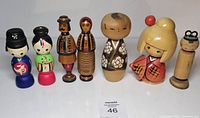 Group shot of all seven wooden dolls standing in a row
