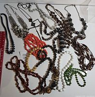 Overview of all necklaces laid out showing variety of colors and materials