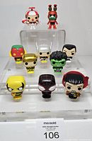 Group shot showing all ten mini vinyl figures on clear tiered stand