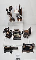 All seven bronze-tone novelty pencil sharpeners displayed on risers