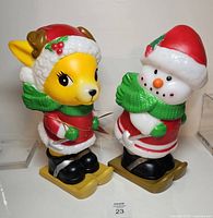 Front view of reindeer and snowman blow molds standing on skis