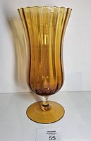 Full view of amber ribbed glass pedestal vase