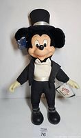 Front view of plush Mickey Mouse in tuxedo and top hat with tags