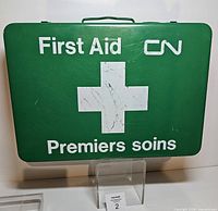 Front view of green CN Rail first aid case with white cross and bilingual lettering