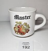 Front of mug showing "Master" text and fruit design