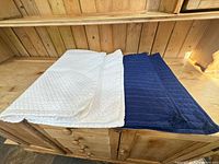 White and navy quilted pillowcases and shams laid flat showing color contrast and quilting