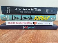 Spines of all four books showing titles and authors