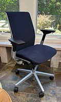 Front angle showing navy fabric seat, back, armrests and aluminum base