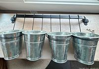 Wall rack with four galvanized buckets hanging
