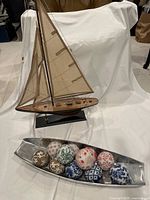 Overall view showing sailboat, metal tray, porcelain balls
