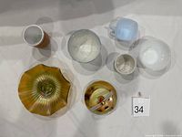 Assorted bowls, cups and carnival glass pieces laid out