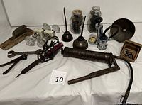 Overall lot layout including grease gun, drill, wrenches, plane, door knobs, oil cans, blow torch, tin, screws