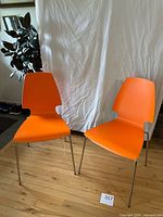 Front view of both orange VILMAR chairs on hardwood floor