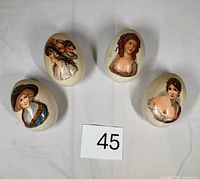 Front view showing all four decorated eggs with portraits