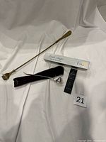 overview of back scratcher/shoe horn, candle snuffer with box, pouch and card