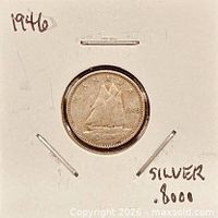 Coin in cardboard flip showing reverse side with Bluenose schooner and 1946 date
