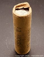 Full view of roll standing upright, torn end showing coin