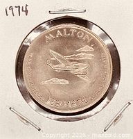 Obverse view of coin in holder showing airplane design and date