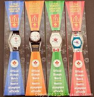 All four boxed Olympic watches showing colour sleeves and dials