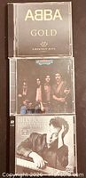 Front view of three CD cases stacked: ABBA Gold, Meat Loaf Welcome to the Neighborhood, Billy Joel Greatest Hits Vol I & II