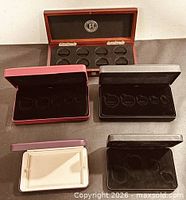 All five coin display cases open, showing interiors