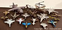 Group view of all toy aircraft on dark surface