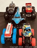 Front view of five monster trucks displaying overall designs and condition