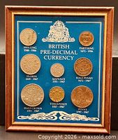 Full view of framed British pre-decimal coin set, eight coins on blue board