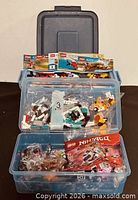 Open Rubbermaid tote showing bagged Lego pieces and instruction manuals