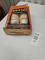 Full view of opened Bar-B-Q Handi-Handle box holding stacked paper cups