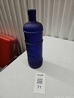 Full view of cobalt blue glass bottle on table