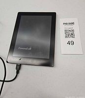 Front view Kobo eReader with cable connected, lot tag visible