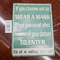 Front of green humorous metal sign showing text and surface wear
