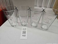 Four clear etched McDonald's pint glasses displayed front view