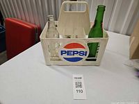 Overall lot showing Pepsi crate with three bottles