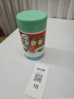 Front view showing green lid, cartoon children graphics