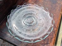 Top view of clear glass footed cake plate showing Cornflower cut pattern and scalloped rim