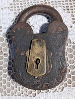 Front view of cast iron railroad padlock, brass dust cover closed