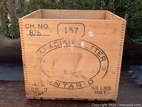 Front view of pine butter box showing stenciled graphics and finger-joint joints