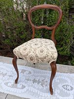 Full view of chair showing balloon back, cabriole legs, and upholstery