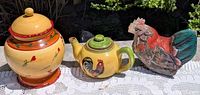 Overall view: ceramic canister with lid, ceramic teapot with lid, wooden rooster