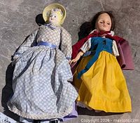 Pair of two vintage dolls lying side by side fully clothed